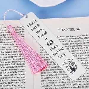 Marque-page en bois avec pompon rose et citation humoristique posé sur un livre