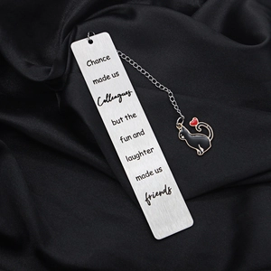 Detail of engraved quote on stainless steel bookmark with a black enamel cat pendant