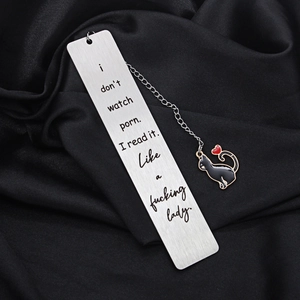 Macro shot of stainless steel bookmark with black cat pendant on black silk fabric
