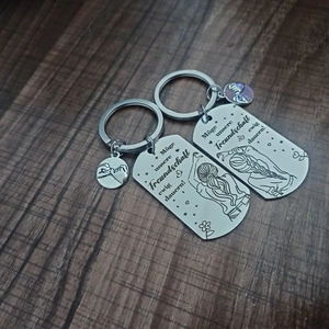 Polished stainless steel keychain set with German friendship engraving on wood background