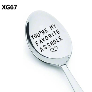 Detail macro shot of stainless steel spoon with humorous engraved text and heart symbol