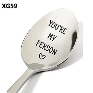 Macro view of polished stainless steel spoon engraved with You're My Person and a heart