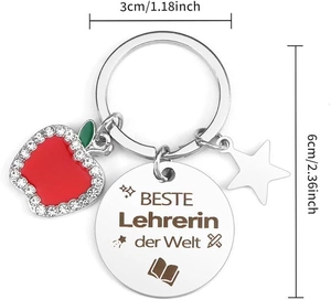 Detail of silver teacher keychain with red apple charm, star pendant, and engraved round disc