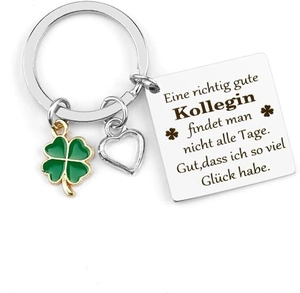 Detail of stainless steel keychain featuring a green clover and engraved message plaque