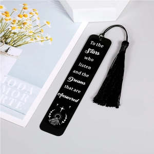 Détail d'un marque-page noir en acier inoxydable avec pompon et citation gravée