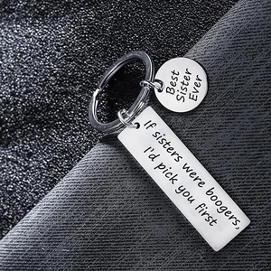 Stainless steel keychain with polished Best Sister Ever engraving on gray fabric background