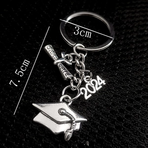 2024 Graduation Keychain with airplane and compass charms on black mesh background