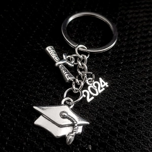 Silver 2024 graduation keychain with mortarboard, scroll, and globe for students