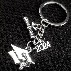 Silver 2024 graduation keychain with airplane compass and graduation scroll charms