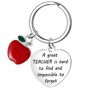 Macro shot of stainless steel heart tag with teacher tribute and red apple charm