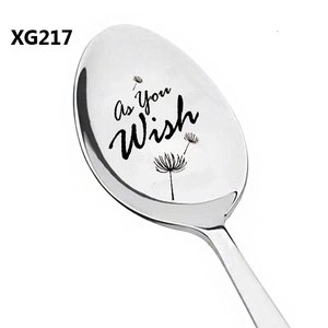 Detailed close-up of stainless steel spoon with laser-engraved dandelion and text