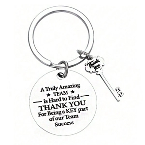 Stainless steel keychain with engraved teamwork quote and key charm on white background