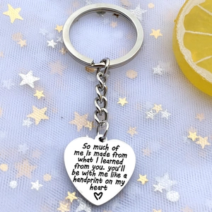 Macro detail of heart-shaped stainless steel keychain with engraved teacher appreciation quote