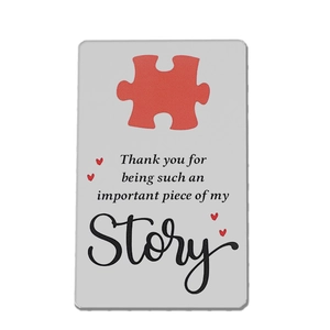 Detail of metal wallet card with puzzle piece design and sentimental thank you text