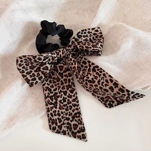 Detail of leopard print ribbon bow hair scrunchie with soft chiffon fabric texture