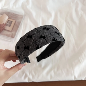 Detail of grey flocked bow headband featuring black diamond patterns and non-slip inner lining