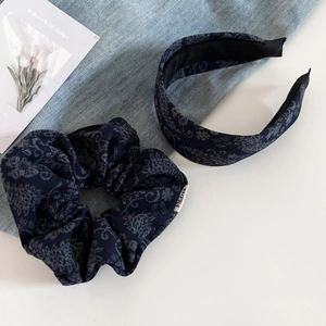 Macro detail of blue paisley wool fabric headband and matching scrunchie set