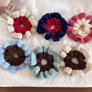 Flat lay of 6-piece knit scrunchies set in various contrasting colors on white fabric