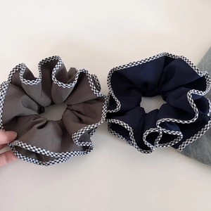 Détail de chouchous surdimensionnés marine et taupe avec bordure en vichy rétro