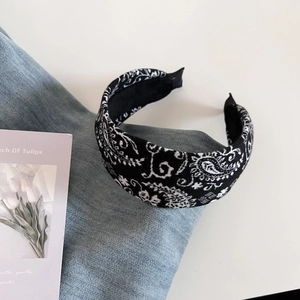 Detail shot of vintage paisley wool headband on denim fabric with tulip card