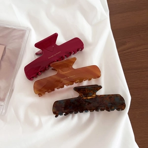 Three-piece acetate hair claw set in tortoiseshell and marble patterns on white fabric