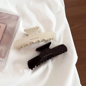 Detail view of premium cream and coffee brown acetate hair claws with geometric patterns