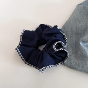 Détail du chouchou bleu marine avec bordure vichy et texture du tissu délicat