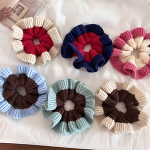 Detail of six colorful knitted scrunchies with wavy ruffle edges and two-tone texture