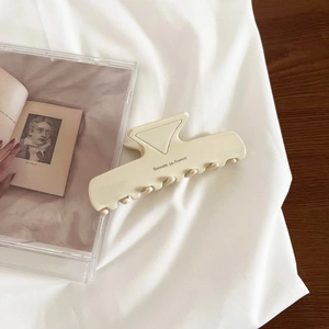 Detailed close-up of cream acetate hair claw clip with Barrette La France gold lettering