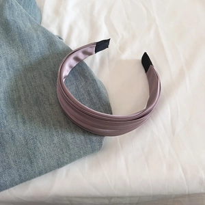 Gros plan sur le serre-tête en satin violet Morandi avec design plissé à plusieurs couches