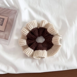 Close-up of knit scrunchie with coffee brown texture and white ruffled edge detail