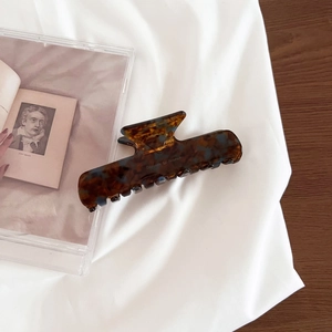 Detail of tortoiseshell acetate hair claw clip with Barrette la France logo lettering
