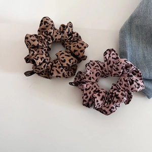 Detailansicht der Haar-Scrunchies mit Leopardenmuster in Braun und Lila mit Stoffetikett