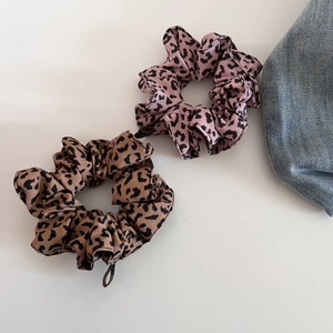 Nahaufnahme von rosa und khaki Haargummis mit Leopardenmuster aus Stoffgewebe