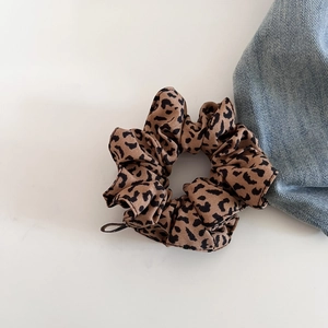 Detailansicht eines Vintage-Haargummis mit Leopardenmuster, weichem Stoff und elastischem Design