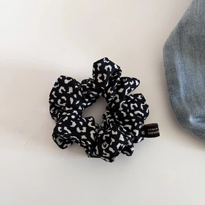 Detail eines großen Haargummis mit schwarz-weißem Leopardenmuster und Korea-Textil-Label
