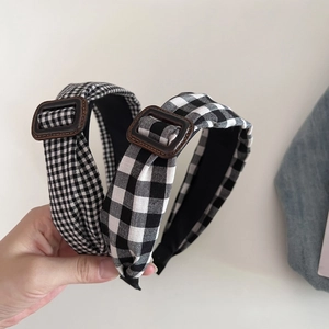 Detailed close-up of checkered fabric headbands with elegant brown leather buckles