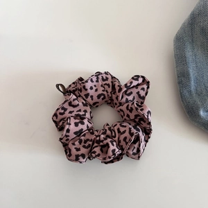 Detail von rosa Leoparden-Haargummi aus weichem Chiffon-Stoff auf weißem Hintergrund