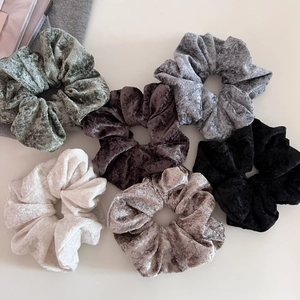 Detailed close-up of soft velvet scrunchies in six colors with embossed texture