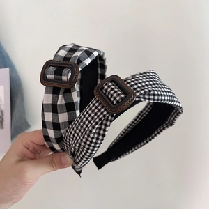 Close-up of retro black and white checkered headbands with stylish square buckle detail