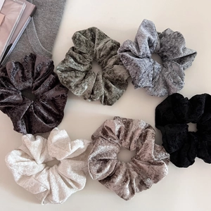 Detailed close-up of velvet scrunchies set in various colors with elegant soft texture