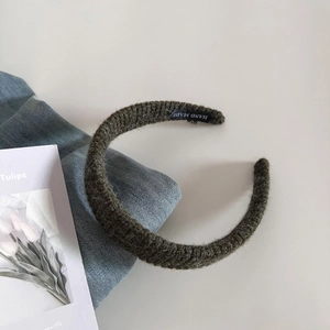 Vue détaillée d'un bandeau en maille foncée avec étiquette fait main et texture en laine