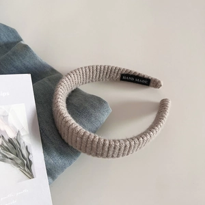 Détail d'un bandeau en maille beige avec une étiquette Handmade cousue à l'intérieur
