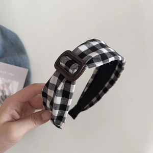 Detail of checkered headband featuring a vintage brown buckle and non-slip inner lining