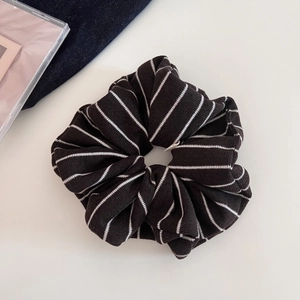Détail d'un grand chouchou en maille avec tissu côtelé noir et rayures blanches