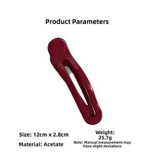 Close-up of a deep red handmade acetate hair clip with elegant hollow oval design