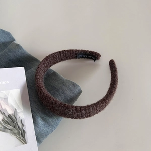 Vue détaillée du bandeau en maille marron montrant la texture et l'étiquette à l'intérieur