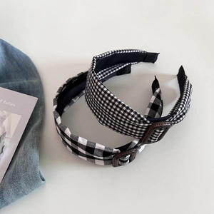 Detailed view of black and white gingham headband with vintage brown buckle accents