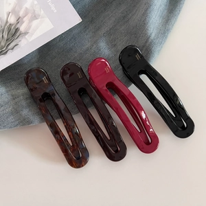 Detail view of oval cellulose acetate hair clips with France Handmade gold lettering