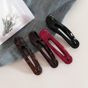 Set of four elegant acetate hair clips in tortoiseshell and solid colors on denim